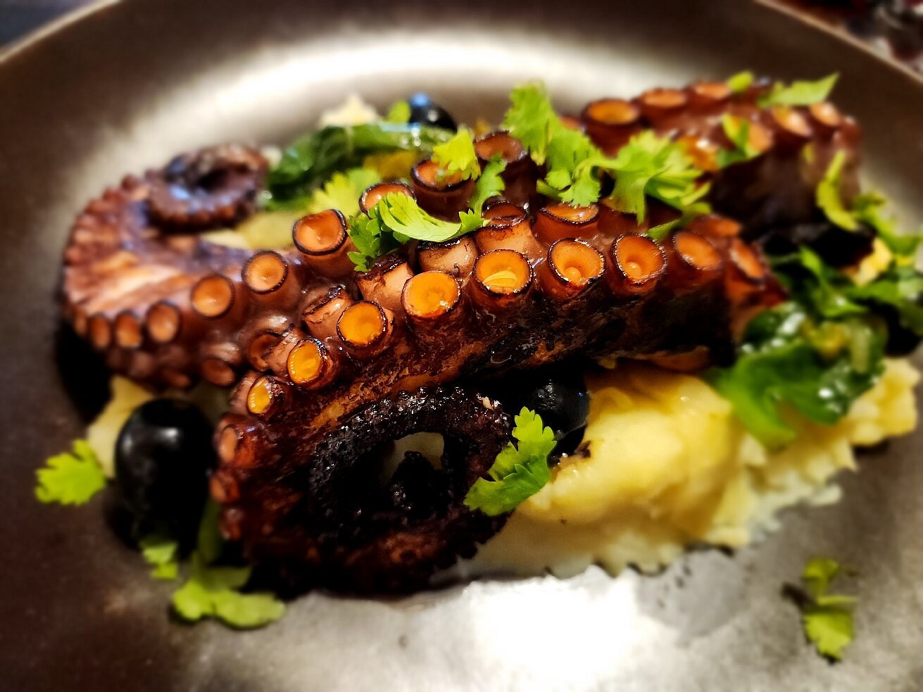 Grilled octopus with mashed potato and olives