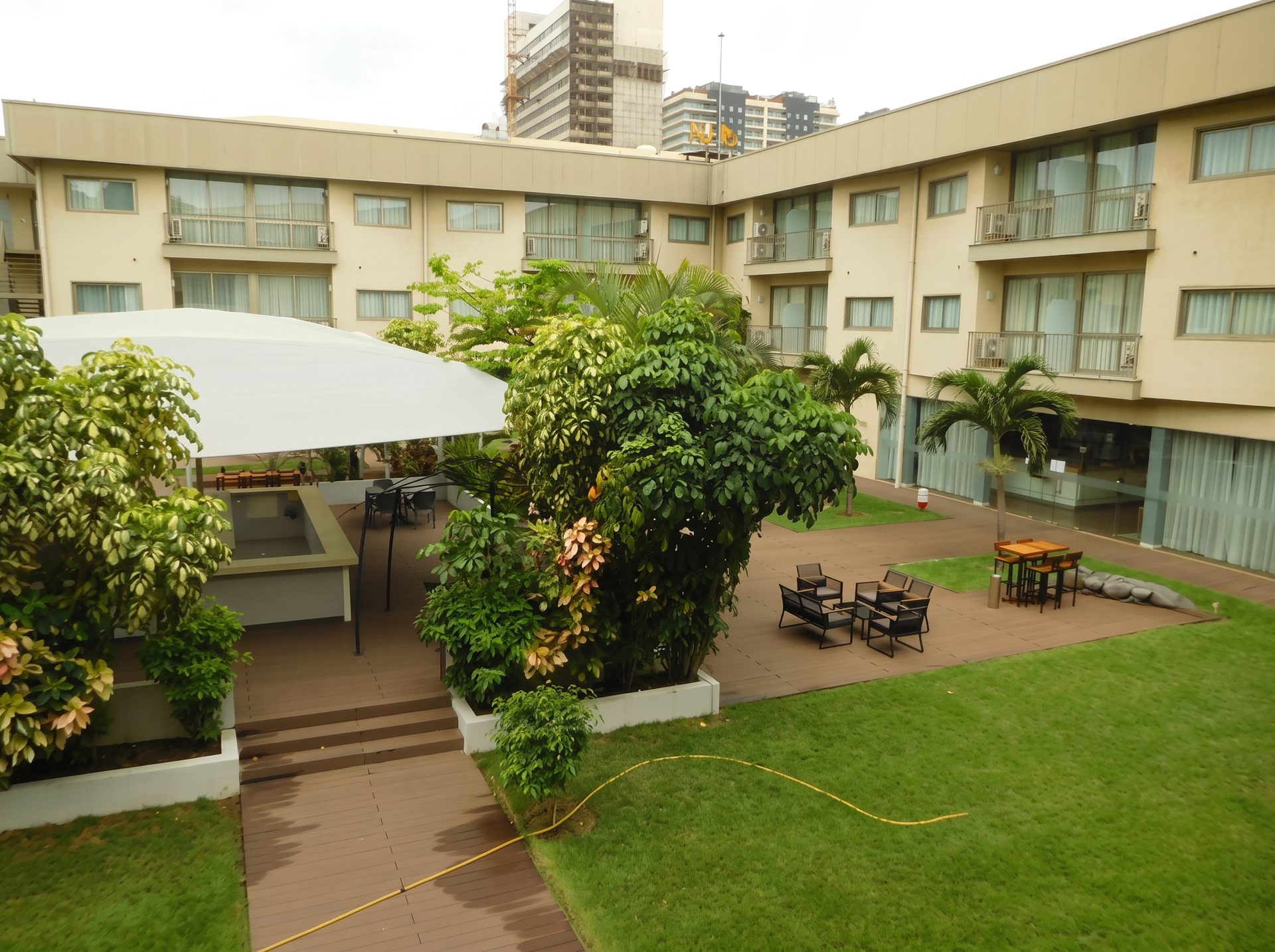 Fórum Gesthotel's garden courtyard with lawn, palms and outdoor seating